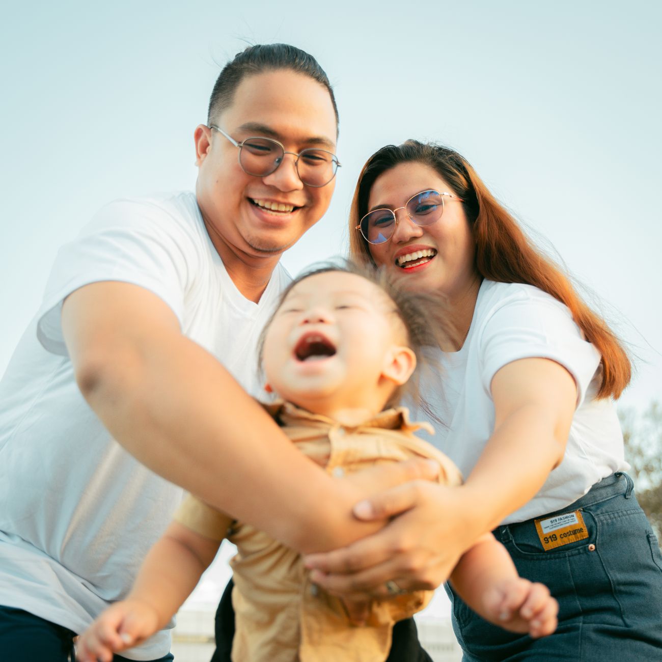 A parent and child sharing a joyful moment outdoors on a sunny day